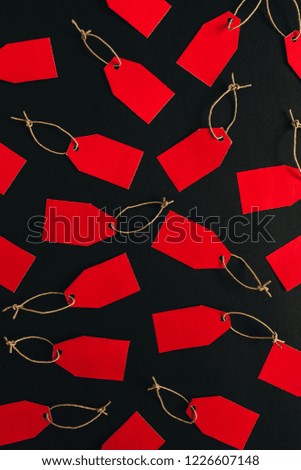 Black Friday sales discount composition. Red tags on black background. Flat lay, top view.