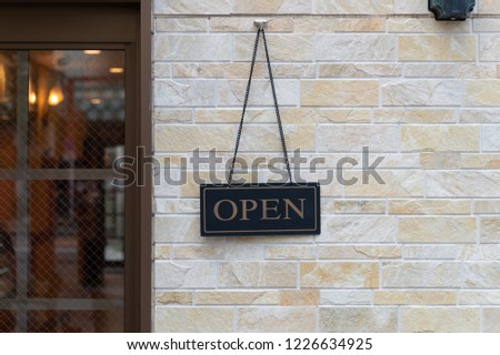 Open Sign Hanging on a Brick Wall