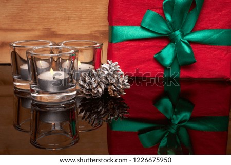 Candles in candlesticks and a gift stand on a glass table