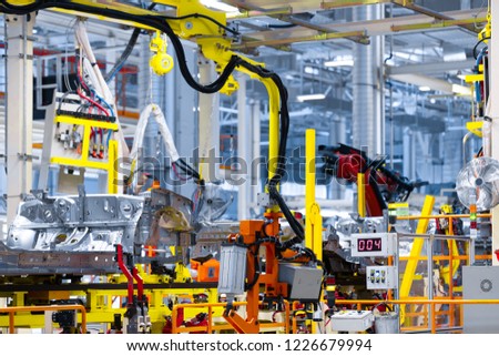 robot arm holds the detail of car. Car manufacturing plant