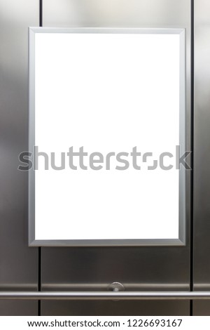 Mock up. Vertical poster media template frame hanging on the wall in elevator lift.