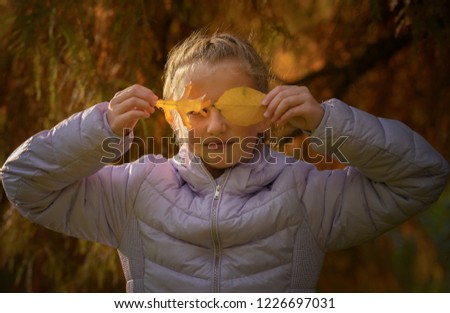 Happy girl laughing and playing in autumn leaves