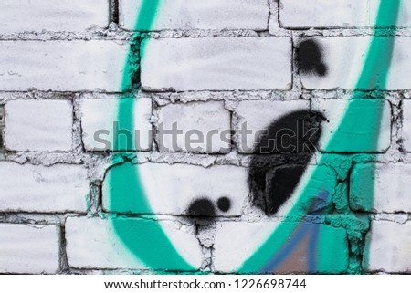 Fragment of colored graffiti painted on a brick wall. Texture. Abstract background for design.