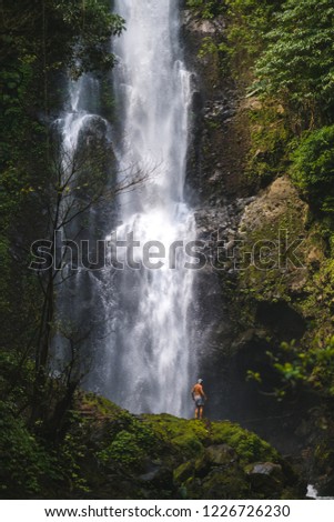 man on the background of a large waterfall
