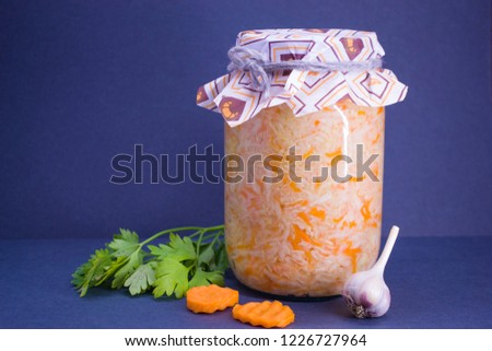 Salted cabbage in a glass jar prepared for the winter and garlic and black pepper and parsley.