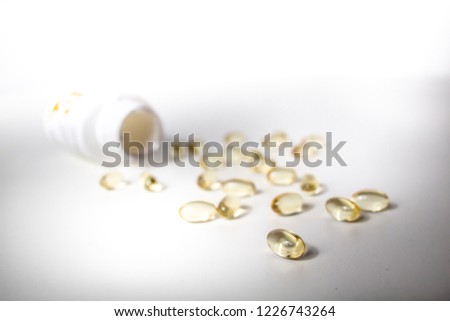 Yellow translucent capsules of food supplement isolated on white background