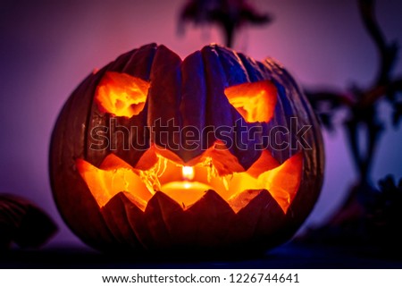Scary halloween pumpkin. Dark background with colorful lights. Halloween theme. Scary postcard. Horror face. Card invitation. Spooky, evil, celebration