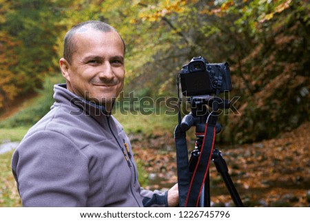 Professional photographer shooting with camera on tripod in a canyon
