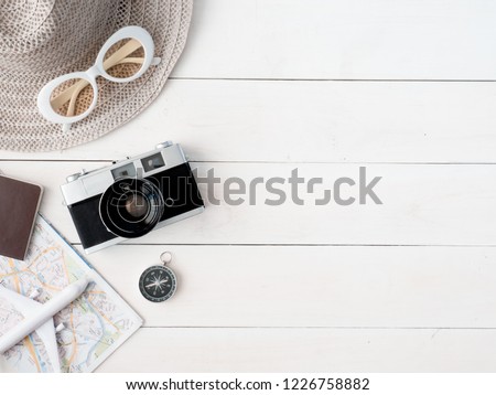 top view travel concept with retro camera films, map, passport, smartphone on white table background with copy space, Tourist essentials, vintage tone effect
