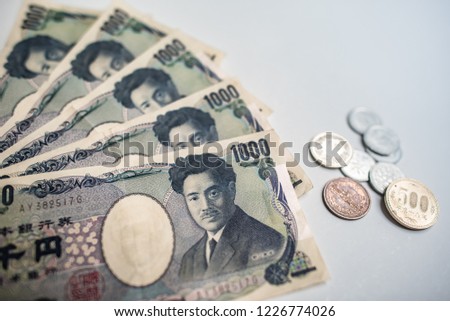 Banknotes of Japanese currency yen background, JPY money with handholding it and many Japanese coins on white background