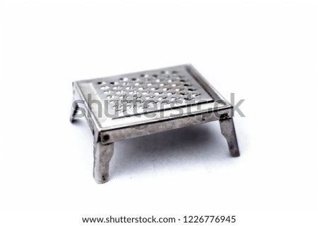Square shaped cheese or butter grater isolated on white,close up view.