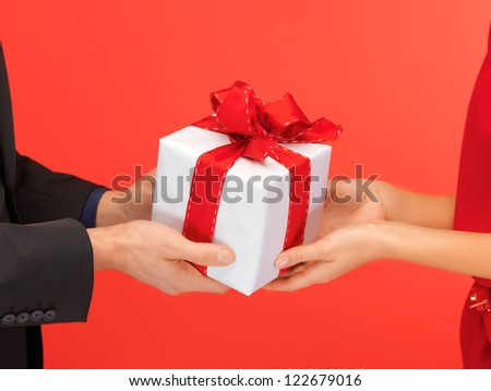 closeup picture of man and woman's hands with gift box