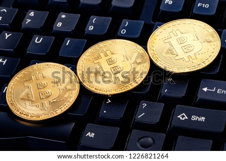 Close-up shot of golden bitcoin cryptocurrency on top of computer keyboard