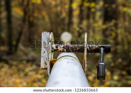 Barrier in the forest with a rusted lock