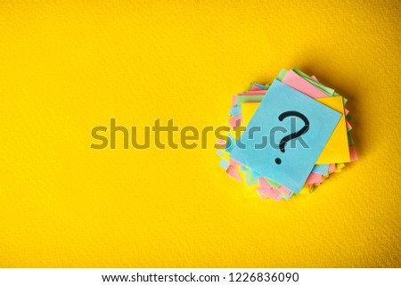 question marks written reminders tickets on yellow vintage paper background.