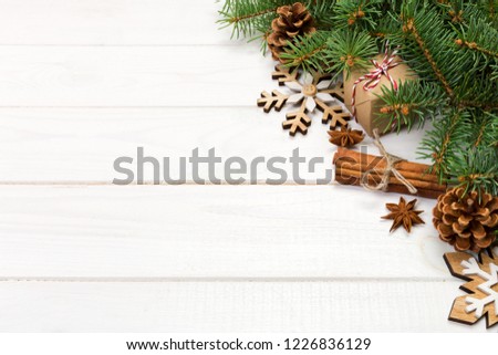 Christmas background with fir tree and gift box on wooden table. Top view with copy space for your design.
