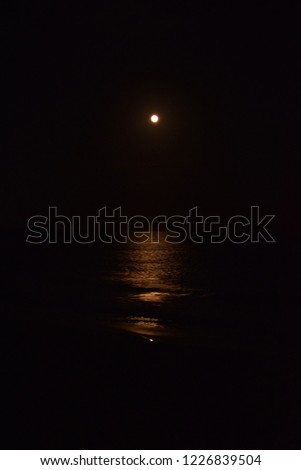 Dramatic sky during moon rise with moon light reflection on the water over the ocean on the outer banks in Hatteras island, North Carolina, USA