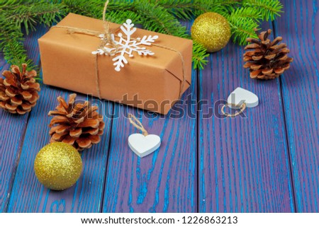 Christmas decoration, gift box and pine tree branches on wooden background