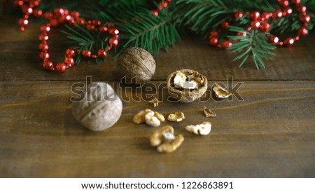 Christmas background, walnuts, shell, fir tree branch and red bead balls Christmas decoration in shape of a heart on rustic wooden table. New Year Valentine day Valentine's concept.