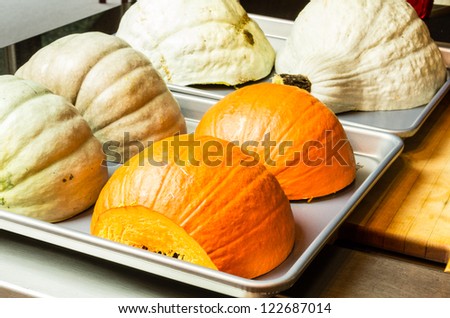 Squash and pumpkin halves on baking trays
