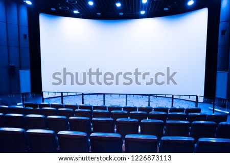Empty stage in the small movie theater with white isolated screen