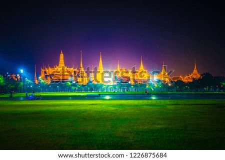 Wat Phra Kaew, Temple of the Emerald Buddha,Grand palace in night lights over green grass of Sanam Luang park at twilight in Bangkok, Thailand