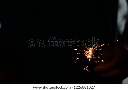 Sparkler fire in hand on black isolated background