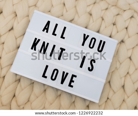 ALL YOU KNIT IS LOVE word on lightbox on knit background. Cozy compozition. Knit wool background.	