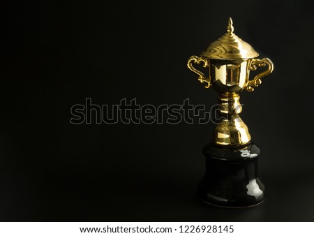Golden trophy over black background. Winning awards with copy space for text and design.