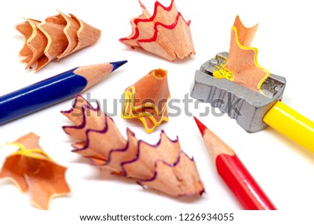 Color pencil and prism sharpener macro photo on white background. Drawing as hobby banner template. Sharpening pencils concept. Yellow, red and blue crayons closeup. Children creative development