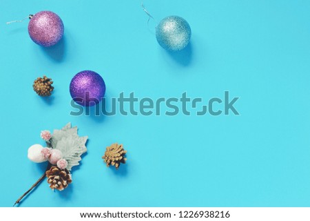Flat lay photography Christmas decoration. New Year baubles, colorful glitter balls, winter decorative branch with pine cones and mistletoe berries. Copy space