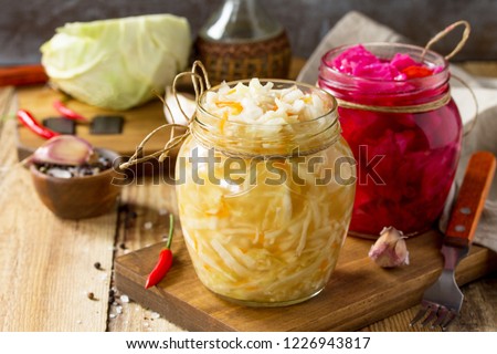 Sauerkraut variety preserving jars. Homemade Sauerkraut with Carrot and Salad Cabbage with Beetroot on a wooden table. Fermented food. Copy space. Royalty-Free Stock Photo #1226943817