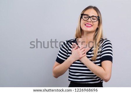 Woman with heartfelt expression on a gray background
