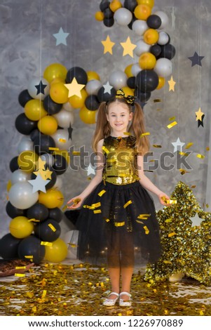 Movie super star girl model posing in studio shoot with golden star and colorful baloons wearing stylish gold airy dress with shining bow tie.Super star pillow deisigned by photographer