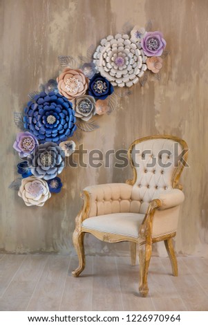 Cozy retro stylish home with decor inspired by designers and florist soul with royal colors. old fashion furniture chair in studio shoot with cosy paper flowers on background brown wall.