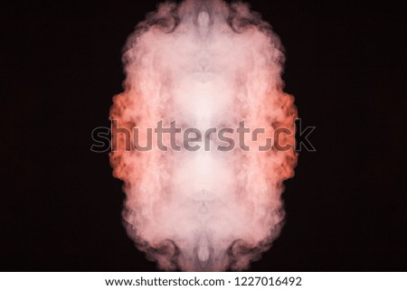 Abstract thick colored smoke orange and pink colour on a black background with a monster face. The concept of a light laser show at a musical concert and a print on a T-shirt