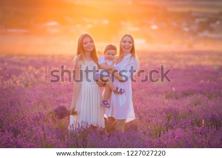Happy mom with cute son and sister on lavender background. Lavender landscape with lady and kid enjoying aroma and vivid colors. Family picture in colorful lavender view.