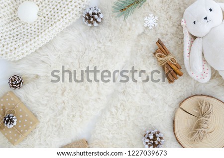 Flat lay fur background with pine cone fir branch,rope,rabbit toy, cinnamon.Top view copy space mockup. Cosy, soft ,minimal. Christmas,new year, birthday, xmas