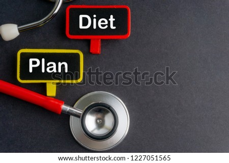 Blackboard with word DIET PLAN and stethoscope on dark background with selective focus and crop fragment. Health and medical concept