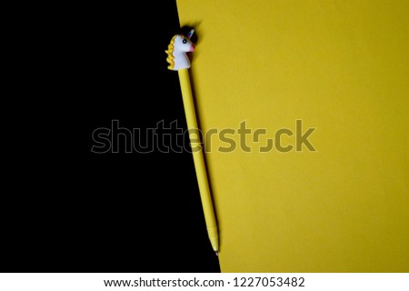 
Pen with a cap in the shape of a unicorn on a yellow-black background