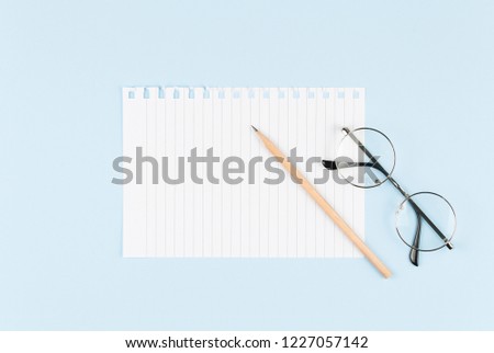one blank sheet with pencil on blue background top view, spiral notepad blank empty sheet. flat lay of office concept