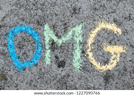 Colorful chalk drawing on asphalt: word OMG