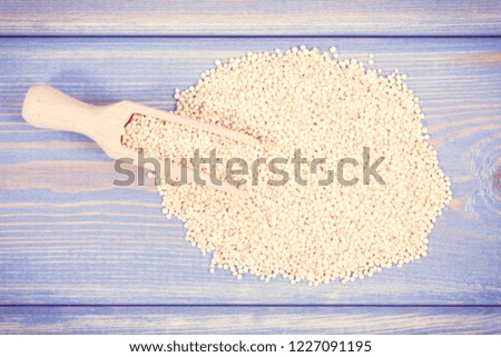 Vintage photo, Heap of quinoa seeds with wooden spoon containing natural minerals and vitamins, concept of healthy nutrition