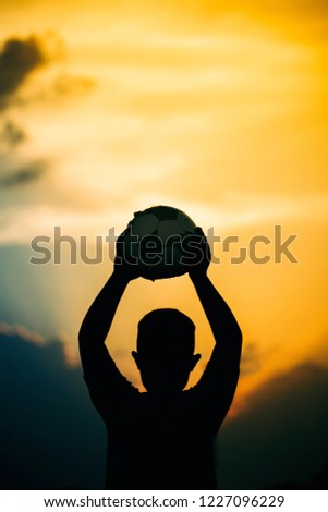 kids are playing soccer football for exercise under the sunlight. Silhouette and film picture style.