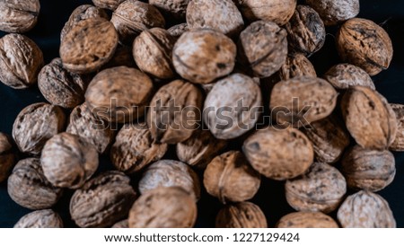 walnuts macro photography, a bunch of nuts with a great texture on black surface and dark background