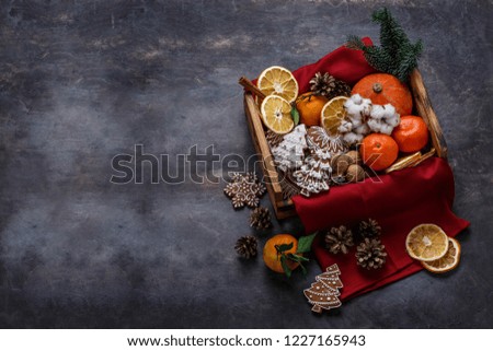 Christmas wooden box filled with gingerbread cookies, dry oranges, tangerines and nuts, copyspace.