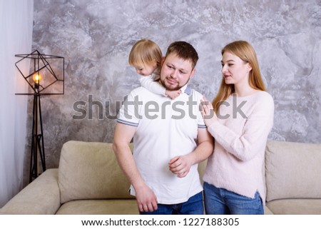 Happy family mother, father and daughter playing and cuddling at home 