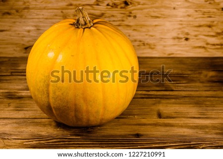 Ripe orange pumpkin on rustic wooden table