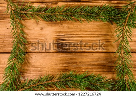 Frame of the fir tree branches on rustic wooden table