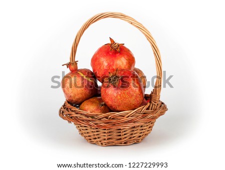 Pomegranates lying in a basket. Pomegranate on a white background.